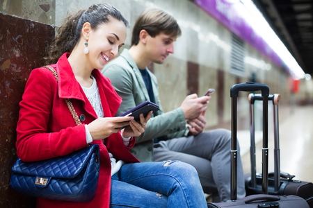 Positive people with tablet and smarthphone at metro stationの写真素材