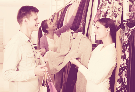 Smiling girl and her young boyfriend with shopping bags at the shopの写真素材