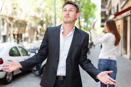 Quarrel between loving couple strolling on city streetsの写真素材