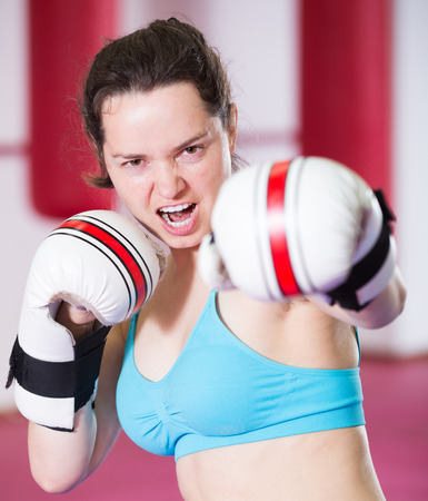 Young sportwoman practicing different kiks in the boxing hallの写真素材