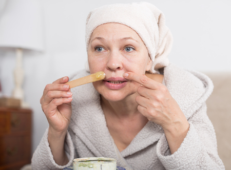 Senior woman starting body hair removal at homeの写真素材