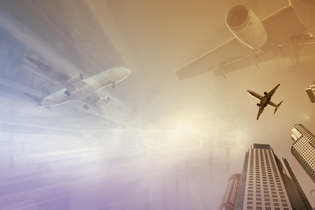 Plane flying on colored background with illuminated cityscapeの写真素材