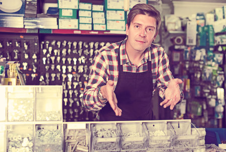 Portrait of employee selling nuts, screw and fasteners in hardware store