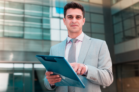 Businessman reading documents and pointing at clause of contractの写真素材