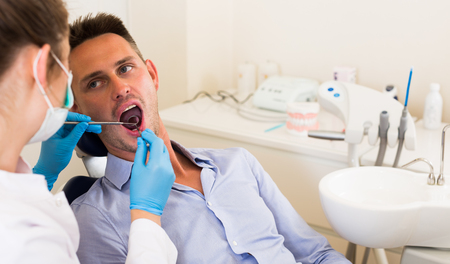 Professional in uniform is examinating young male in clinic.の写真素材