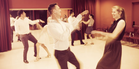Young smiling people practicing dance moves with blurry motion effect