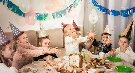 Smiling children having good time during friends birthday partyの写真素材