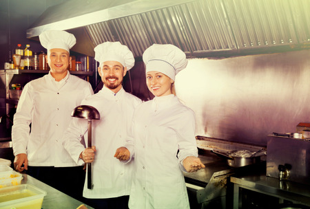 Young professional cooks demonstrating their workplace in restaurantâs kitchenの写真素材