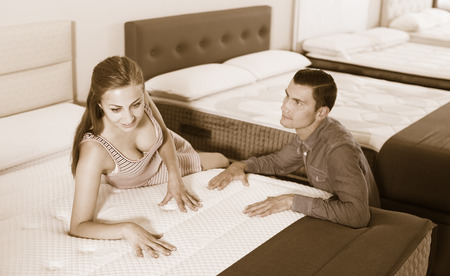 Man and woman choosing mattress in storeの写真素材