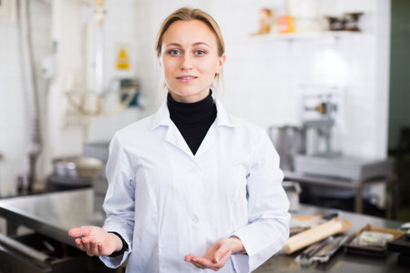 Portrait of young woman working in modern food factoryの写真素材