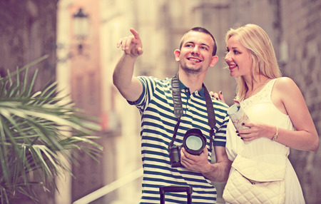 portrait of happy couple tourists taking walk and dragging luggage bags in Barcelonaの写真素材