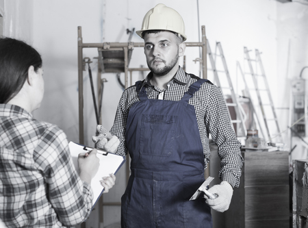 Builder with spatula is talking to client at home.の写真素材