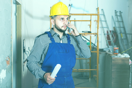 Builder man is speaking report about work for client at the objectの写真素材