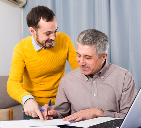 Adult male and sales manager discuss conditions of contract at homeの写真素材
