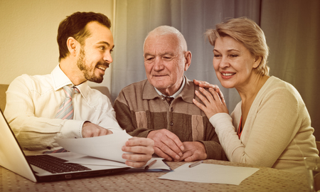 Husband and wife preparing agreement papers with social worker at homeの写真素材