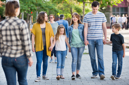 Friendly and glad family going in the park on their weekend togetherの写真素材
