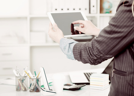 Business woman holding and using tablet at workplace in officeの写真素材