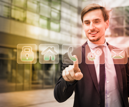 Businessman touching digital interface with finger on industrial business backgroundの写真素材