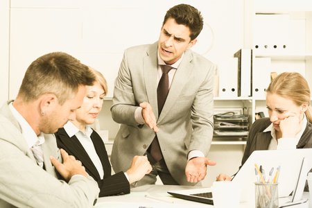 Businessman feeling angry to coworkers in office, pointing out mistakes in workの写真素材