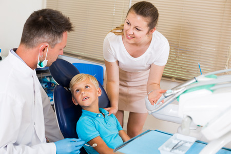 Female with boy are visiting dentist in dental office.の写真素材