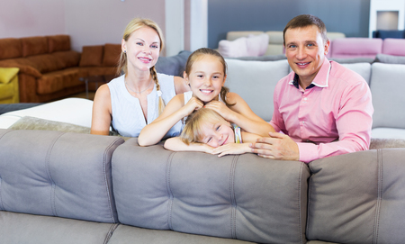 Happy family is choosing new sofa in modern furniture salonの写真素材