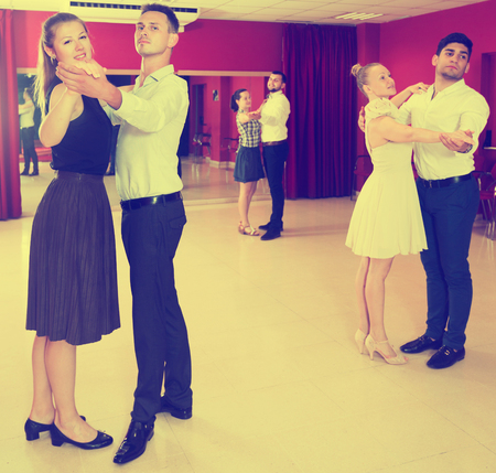 Young positive people dancing together slow ballroom dances in pairsの写真素材