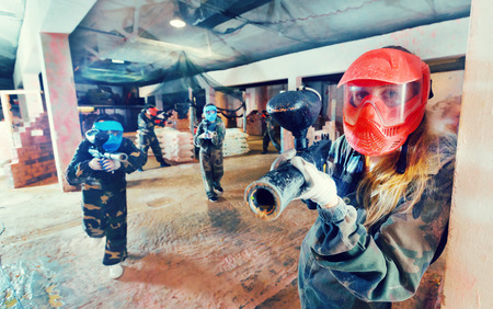 Player in red mask is targeting in enemy in battlefield at the paintball clubの写真素材