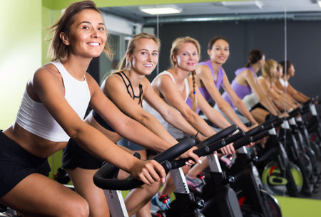 Sporty swedish women on cardio training on exercycles in health club
