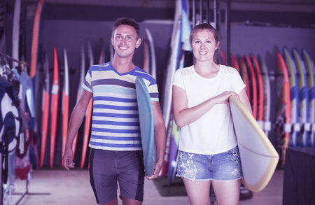 Young couple is ready for surfing with surfboard in summer