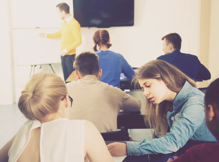 Female student 15-18 years old is curious about test answers in her neighbors work.の写真素材