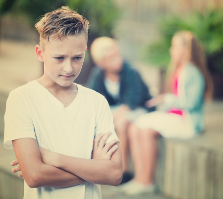 Upset boy offended after quarrel with playmates outsideの写真素材