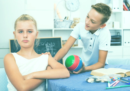 Boy is apologizing to a girlfriend for bad behavior and offering to play ball at home.の写真素材
