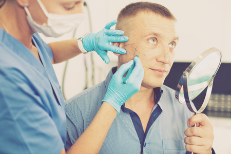 Woman doctor is preparing client for mesotherapy in clinic.の写真素材