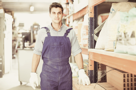 Portrait of diligent working male in uniform on his workplace in building store.の写真素材