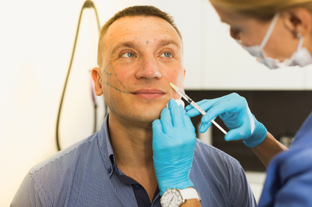 Female specialist is doing injection to client for anti-aging in estetic clinic.の写真素材