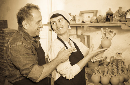 Elderly couple among the pottery at the workshopの写真素材