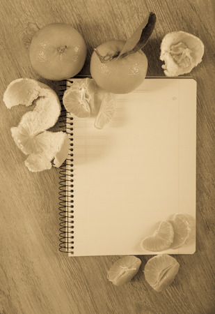 Empty notebook pages lying on table and decorated with tangerinesの写真素材