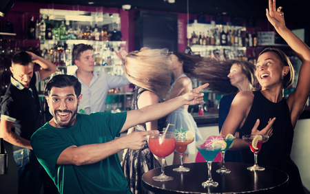 Female with man are dancing and drinking cocktail on the party in barの写真素材