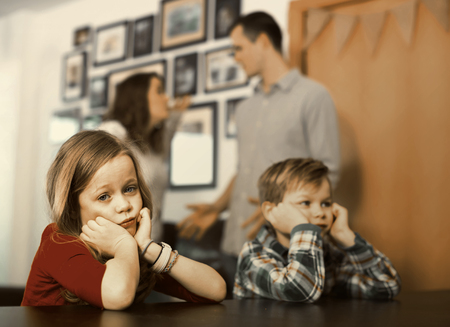 Father and mother with the sad scandal, and children at homeの写真素材