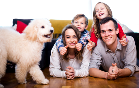 Happy young couple and two children spending quality time together at homeの写真素材