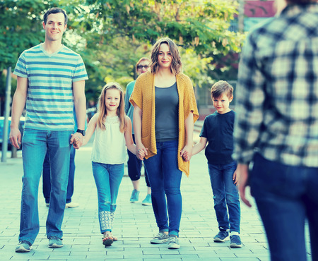 cheerful parent with kids  walking in the park in good weatherの写真素材