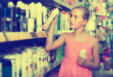 Young girl holding body spray in the hand at the shopの写真素材