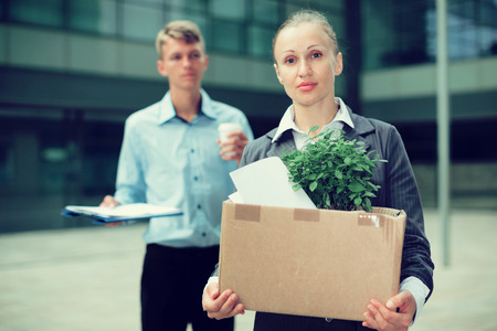 Serious woman is standing upset near office because she was dismissaled.の写真素材