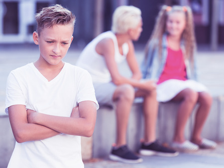 Upset boy offended after quarrel with playmates outsideの写真素材