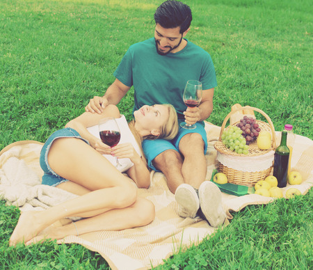Girlfiend is relaxing on the lap of male in time picnic outdoor.の写真素材