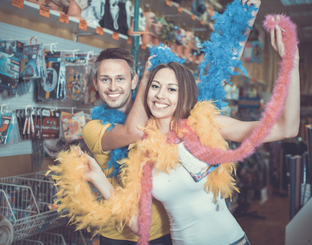 Cheerful smiling glad family couple preparing for fest and showing feather boaの写真素材