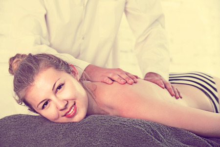 portrait of positive spanish  woman  relaxing on massage table at  spa centerの写真素材