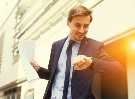 Businessman hurrying to meeting and watching on wristwatchの写真素材