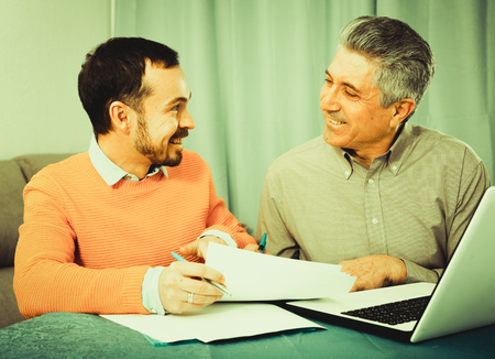 Young man and sales manager discuss terms of contract of purchase at homeの写真素材