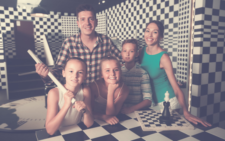 Happy family is visiting of escaperoom stylized under chessboardの写真素材
